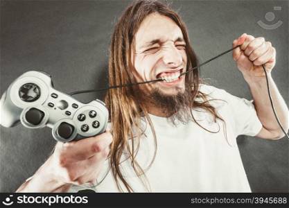 Stressed man playing on pad. Addiction. Stressed depressed young man playing gaming on pad. Angry guy with controller pad play console. Face expression.