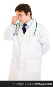 Stressed medical doctor holding fingers at noseband isolated on white&#xA;