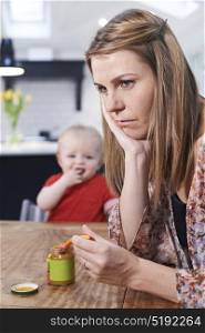 Stressed Mother Trying To Feed Fussy Baby