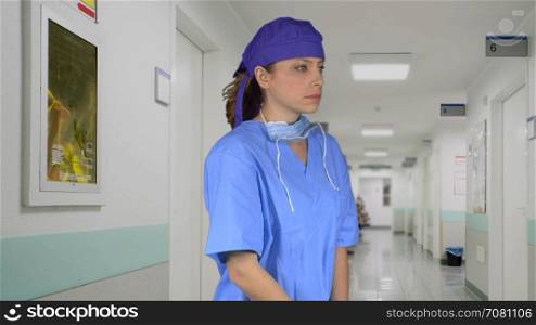 Stressed or sad surgeon wearing a cap in the hallway