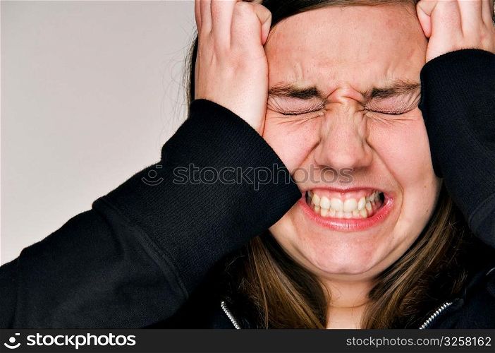 Stressed-out woman with hands to head.