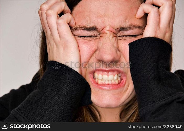 Stressed-out woman with hands to head.