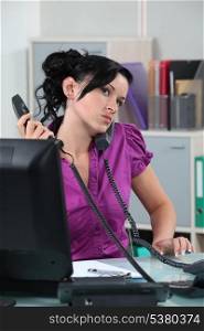 Stressed receptionist taking several calls at once