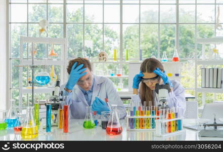 Stressed unsuccessful western scientists couple working failed on test tube to analysis and develop vaccine of covid-19 virus in lab or laboratory in technology medical, chemistry, healthcare.