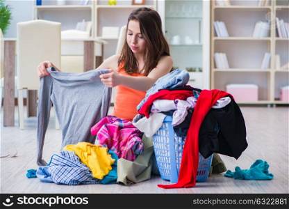 Stressed woman doing laundry at home