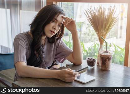 stressed woman having credit card problem to shopping online with tablet at the cafe