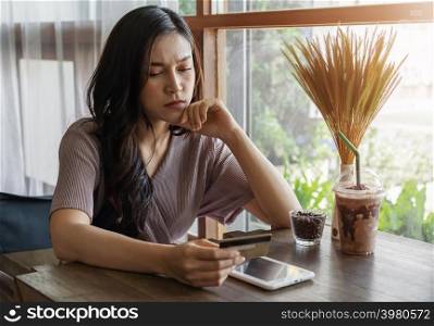 stressed woman having credit card problem to shopping online with tablet at the cafe