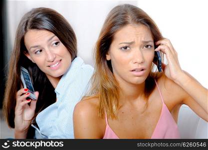 Stressed woman on the phone next to her friend