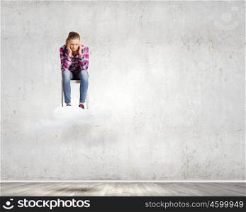Stressed woman. Young troubled woman sitting on chair on cloud