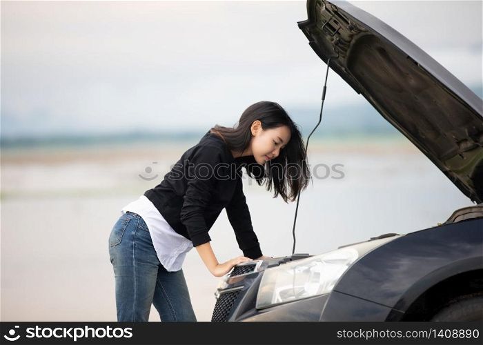 Stressed women after a car breakdown with Red triangle of a car on the road