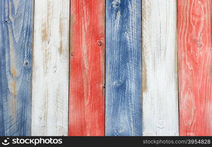 Stressed wooden boards painted red, white and blue for patriotic concept of United States of America. Layout in vertical format.