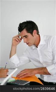 Stressed worker going over accounts