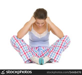 Stressed young woman in pajamas sitting on floor