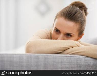Stressed young woman sitting on sofa