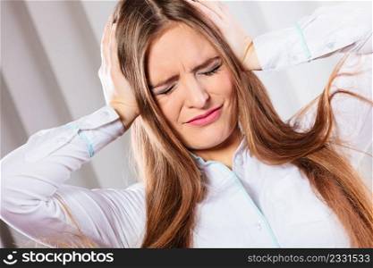 Stressful situations in work. Headache and migraine. Young woman in office pain and emotions.. stressed woman in white shirt with headache