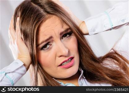 Stressful situations in work. Headache and migraine. Young woman in office pain and emotions.. stressed woman in white shirt with headache