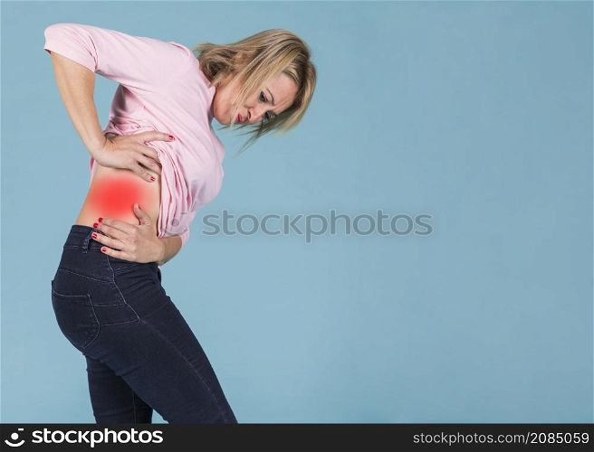 stressful woman suffering from lower back pain blue background