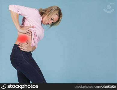 stressful woman suffering from lower back pain blue background