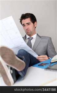 Stressless businessman looking at construction plan
