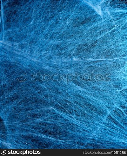 stretched white web with blue backlight, background for the holiday Halloween, copy space