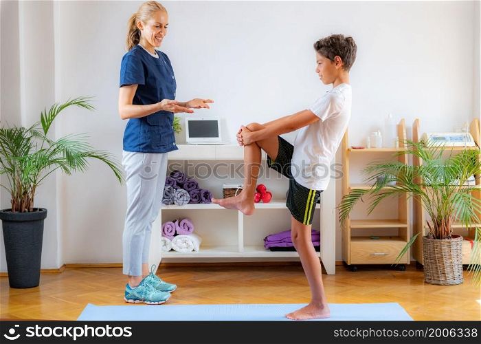 Stretching exercise for children. Boy exercising with physical therapist.