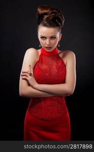 Strict beautiful business woman in red dress isolated on black background