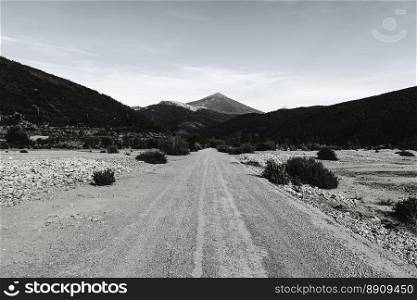 Stright gravel road of Europe Peaks in Spain early morning. Beautiful landscape with dramatic view of Cantabrian Mountains