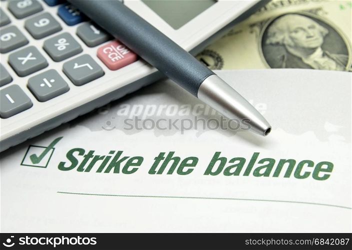Strike the balance printed on book with calculator and pen