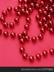 String of red beads on red background.