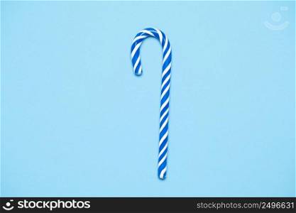 Striped blue and white candy cande on mint blue paper background