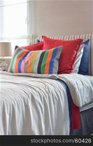 Striped headboard with Colouful pillows and striped pillow on white bed sheet