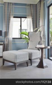Striped high back armchair with ottoman in light blue classic bedroom