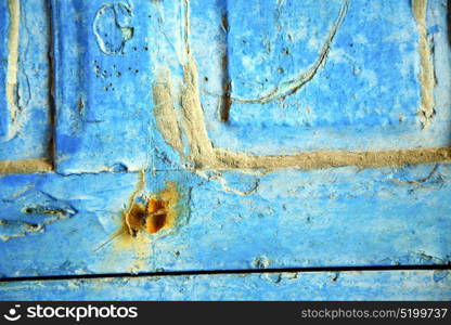 stripped paint in the blue wood door and rusty nail