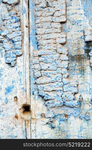 stripped paint in the blue wood door and rusty nail