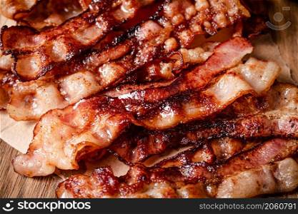 Strips of fragrant fried bacon. Macro background. Bacon texture. High quality photo. Strips of fragrant fried bacon. Macro background.