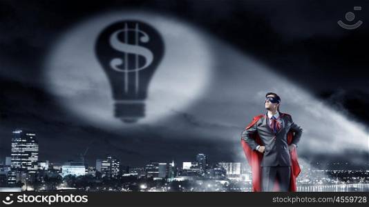 Strong and powerful as super hero. Young confident super businessman in mask and cape at night