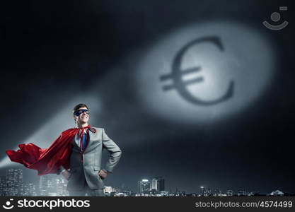 Strong and powerful as super hero. Young confident super businessman in mask and cape at night