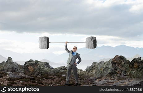 Strong and powerful. Confident businessman lifting above head stone barbell