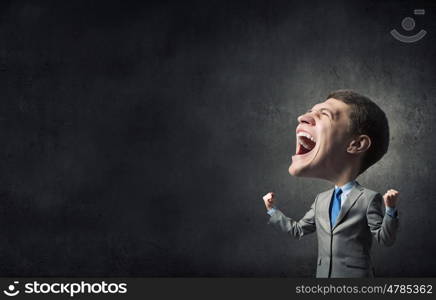 Strong and powerful. Young big headed businessman screaming with his hands up