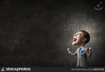 Strong and powerful. Young big headed businessman screaming with his hands up