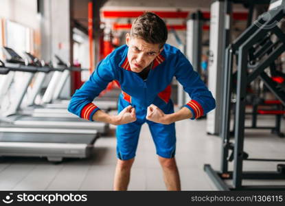 Strong athlete in sportswear, training on exercise machine in gym. Bearded man on workout in sport club, healthy lifestyle. Strong athlete, training on exercise machine