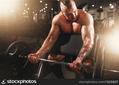 Strong athlete with muscular body lifting barbell, bodybuilding workout in sport gym. Weightlifting training