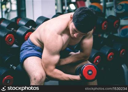 Strong Athletic Asian Man workout with dumbbell curl Concentration muscle upper arm for bodybuilding feeling so strong and powerful,Bodybuilder Concept