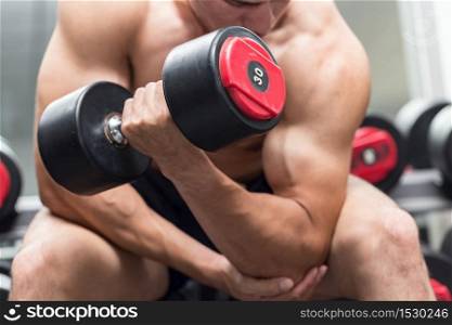 Strong Athletic Asian Man workout with dumbbell curl Concentration muscle upper arm for bodybuilding feeling so strong and powerful,Bodybuilder Concept