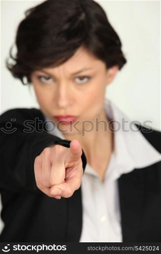 Strong businesswoman pointing at the camera