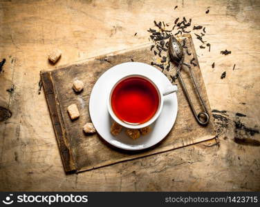 Strong flavored tea with cane sugar. On wooden background.. Strong flavored tea with cane sugar.