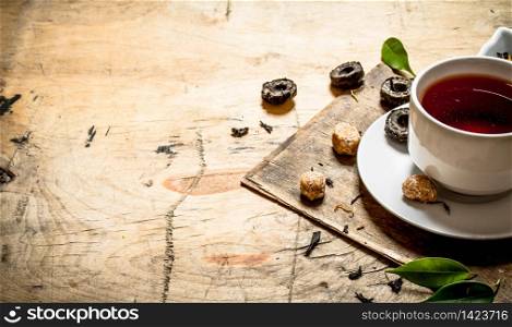 Strong flavored tea with cane sugar. On wooden background.. Strong flavored tea with cane sugar.