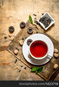 Strong flavored tea with cane sugar. On wooden background.. Strong flavored tea with cane sugar.