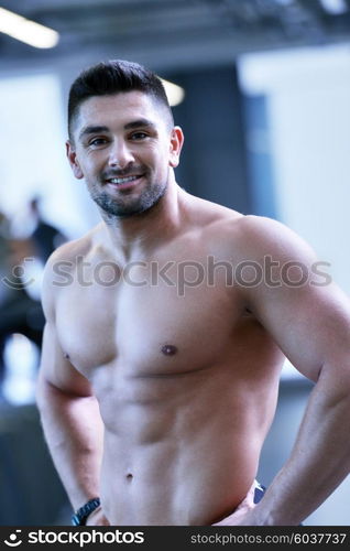 Strong handsome man exercising at the gym