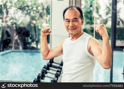 Strong healthy senior grandfather in gym fitness center. Happy retirement lifestyle.